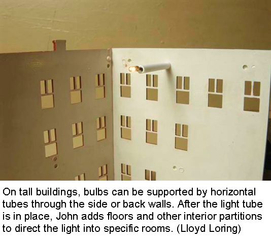 A vertical tube supports most light bulbs inside John's buildings. 
  The white walls behind the lamp reflect light in one direction, while an extra layer of styrene keeps light from showing 
  through the thin plastic walls.  (Lloyd Loring)